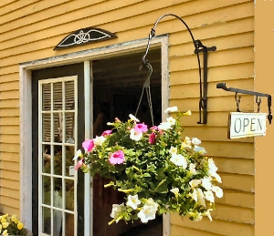 Front of Phyllis's shop with flowers hanging from wrought iron bracket.