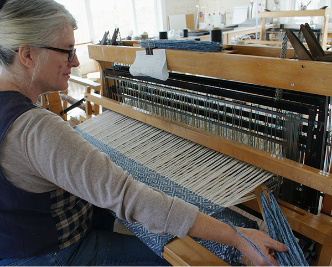 Phyllis using a shuttle at an 8 harness loom.